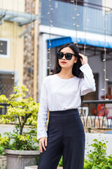 Young Woman in White Long Sleeve Shirt with Glasses Posing