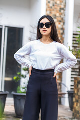 White Long Sleeve Shirt Mockup: Woman with Glasses Striking a Pose Outdoors