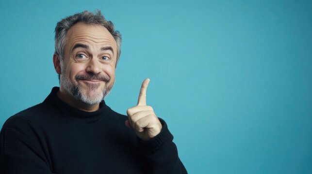 The man is confidently pointing out something, possibly during a lecture or talk show.