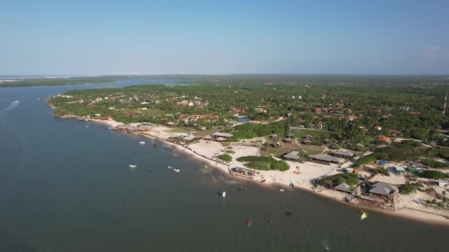 Forward movement of drone flying over Atins, Maranhao, Brazil. Some part of Preguica river, some boats on the river and some people doing kitesurf.