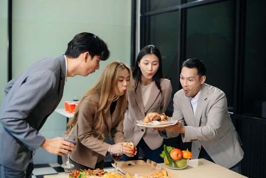 Young Asian Professionals Celebrating with Pizza and Drinks in a Modern Office Setting
