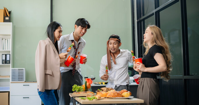 Young Asian Professionals Celebrating with Pizza and Drinks in a Modern Office Setting