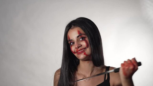 YOUNG HALLOWEEN WOMAN WITH A KNIFE GESTURING TO SLIT HER THROAT