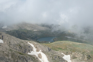 Uludağ glacial lakes. Snowy lake view in cloudy and sunny weather. Lake view in snowy foggy weather. Mountain view covered with blue clouds and snow. Uludağ peak. Bursa, Türkiye.
