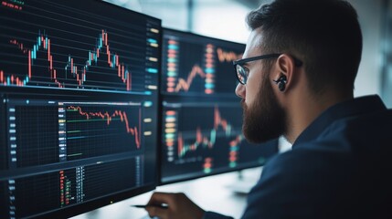 Fototapeta premium A focused businessman analyzes stock market data on multiple monitors.