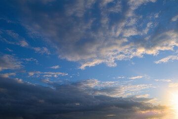 Summer evening sky in the picturesque clouds, lit by the rays of the setting sun.