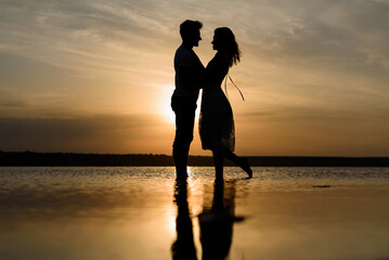 guy and girl in the water at sunset