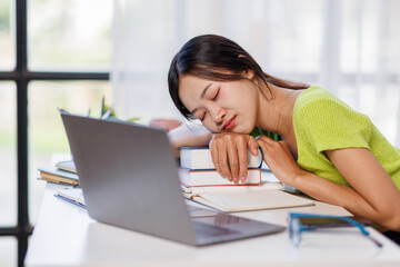 Young woman working on laptop having headache. Bored workaholic female accountant employee with headache and stress. Business asian woman with migraine, stress relief, chronic pain
