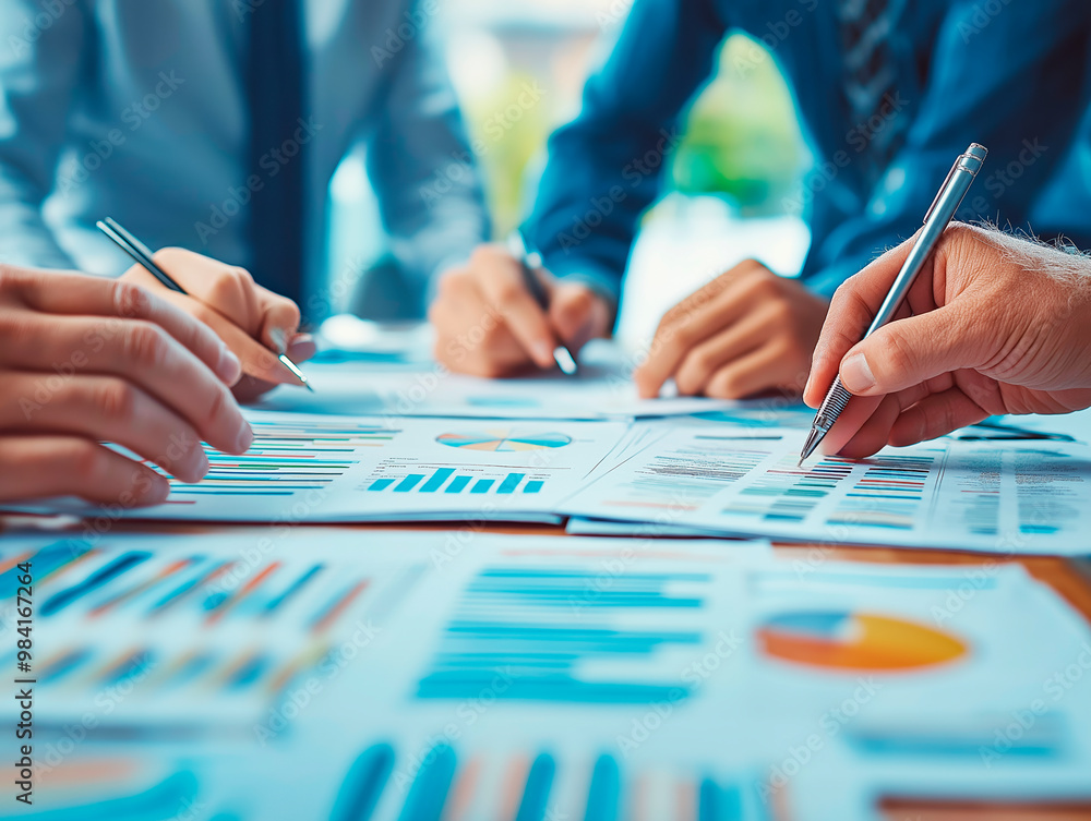 Aufkleber Team analyzing business charts during a workshop, focusing on financial data and strategy in a bright office setting.