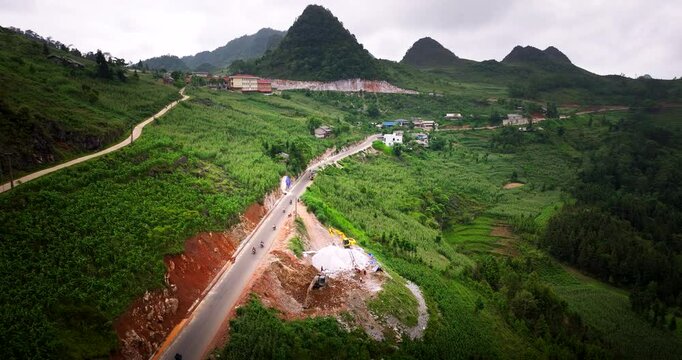 Aerial shot of the Ha Giang Loop in Vietnam, showcasing winding roads and motorbikes and lush green mountains