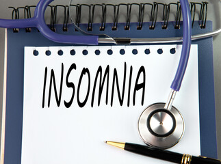 INSOMNIA is a word on a white sheet against a stethoscope.