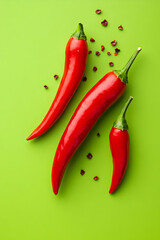 Red hot chili peppers on green background. Top view. Copy space.