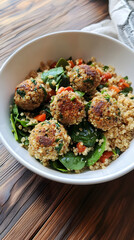 A white bowl filled with quinoa, spinach, and flavorful veggie balls, showcasing a healthy and appetizing meal packed with nutrients and vibrant colors
