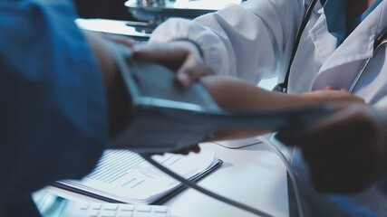 Female doctor using sphygmomanometer with stethoscope checking blood pressure to a patient in the hospital - Powered by Adobe