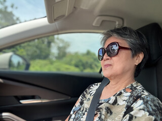 Happy asian elder woman sitting at front seat while traveling by car on holiday, happy life and...