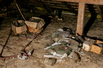 A cluttered, dusty attic full of empty bottles and old boxes, illustrating the need for spring cleaning and organization