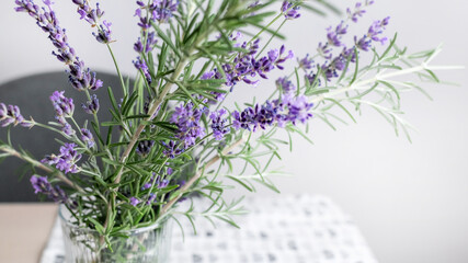 A bouquet of purple lavender sprigs in a glass vase symbolizes tranquility and relaxation, ideal for Mother's Day decor