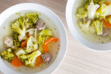 Two bowls of hearty vegetable and meat soup, perfect for a warm and healthy winter meal concept