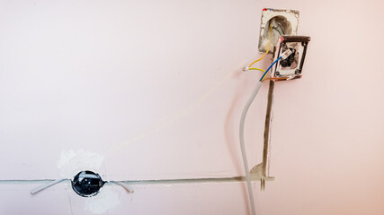 Electrical wiring installation process captured inside a home under renovation demonstrates...