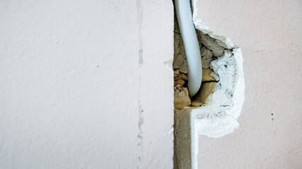 Damaged wall with exposed wiring highlighting home maintenance and repair issues