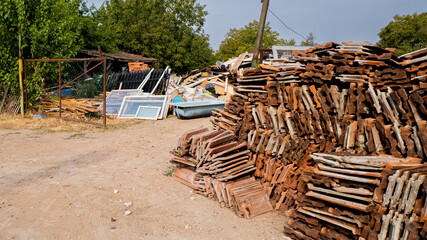 Scrap yard with piles of old construction materials and windows, excellent for themes on recycling, sustainability, and urban waste management