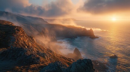 A stunning sunset over a rugged coastline with mist swirling around the cliffs.