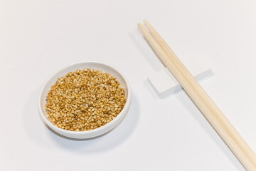 小さな白い器に入った「ゴマと割りばし（sesame seeds and chopsticks）」