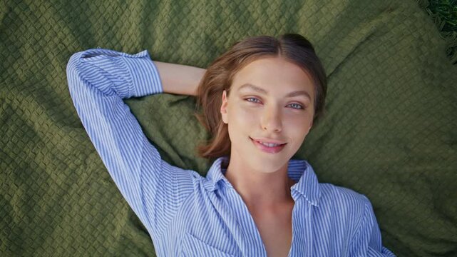 Beautiful model lying park green grass with calm expression top view closeup
