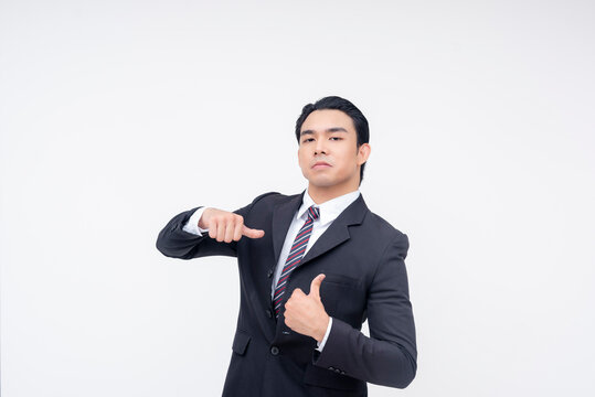 A cocky and insecure young asian business executive pointing to himself,making thumbs up sign. Isolated on a white background.