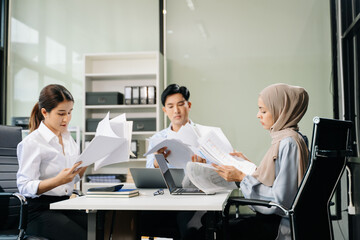  Asian businesspeople while collaborating on a new project.  using a laptop and tablet