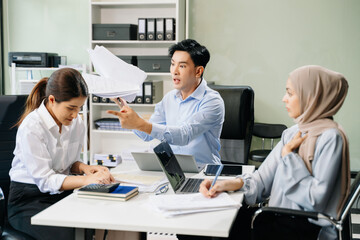 Furious two Asian businesspeople arguing strongly after making a mistake at work