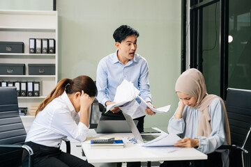 Furious two Asian businesspeople arguing strongly after making a mistake at work