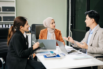  Asian businesspeople while collaborating on a new project.  using a laptop and tablet