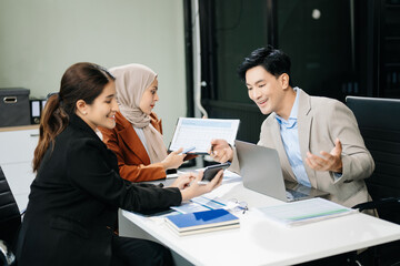  Asian businesspeople while collaborating on a new project.  using a laptop and tablet