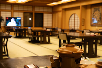 Traditional Japanese dining hall with wooden decor and tatami mats.
