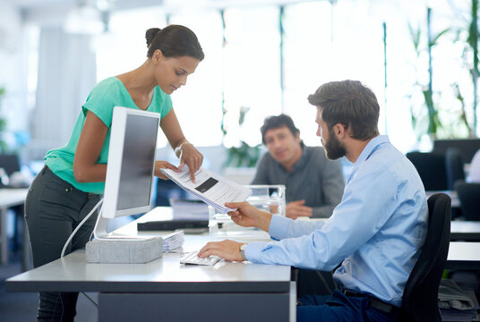 Business people, documents and discussion with company policy for contract, application or agenda at office. Young, group or designers with paperwork on computer for data entry or report at workplace