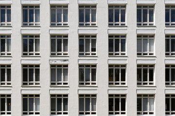 A white building facade full of windows.