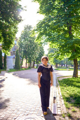 Fototapeta premium a medium size woman in a black corset and wide leg trousers walks through the city in the morning light