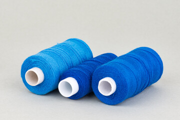 Blue thread spools on grey background
