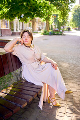          a plus size woman in a peach fuzz dress walks through the morning city