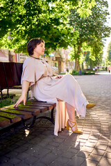          a plus size woman in a peach fuzz dress walks through the morning city