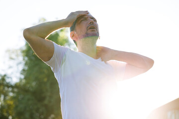 Young man having hot flash and sweating in a warm summer day