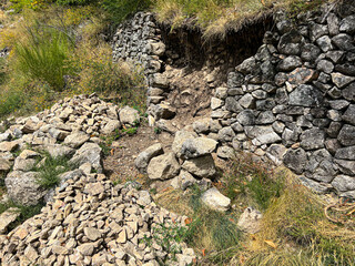 Crumbling stone wall slowly being reclaimed by nature