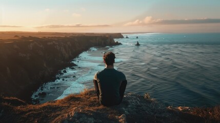 Obraz premium Person Sitting on Coastal Cliff Edge Watching Ocean Sunset Nature View Scene