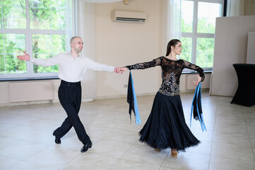 Couple of professional dancers, man and woman, dance tango in stage costumes, to rhythm of music....