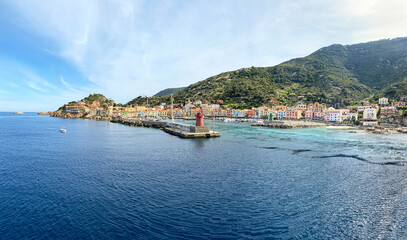 Fototapeta premium View to harbour and old town of Giglio Porto at Isola del Giglio, island of the tuscan archipelago, beautiful ancient rustico buildings and ferry terminal to Porto San Stefano, Grosseto Tuscany Italy