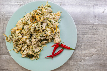 Food Concepts. Closeup of Spiced Boiled Shredded Chicken Meat With Red Pepper On Blue Ceramic Plate...