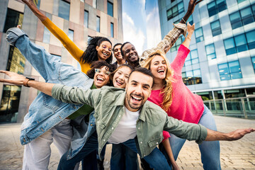 Multi ethnic young people smiling together at camera outdoors - Happy group of friends having fun...