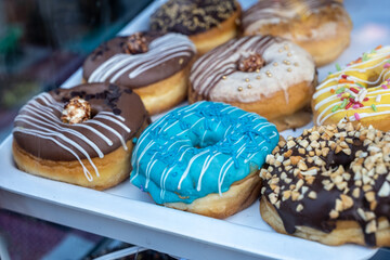 A Variety of Glazed and Topped Donuts on a White Tray