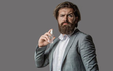 Male fragrance and perfumery, cosmetics. Bearded man holding up bottle of perfume. Fashion cologne...
